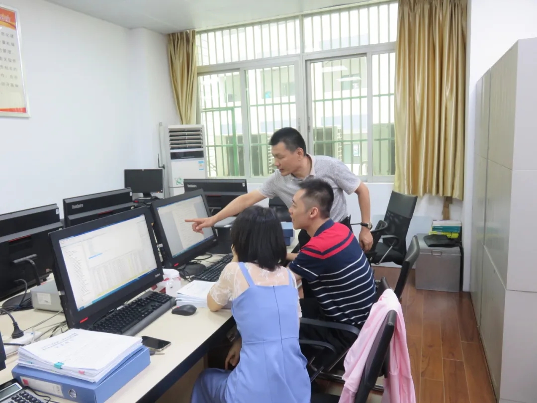 图为周航（中间）在大数据审计现场进行数据核对