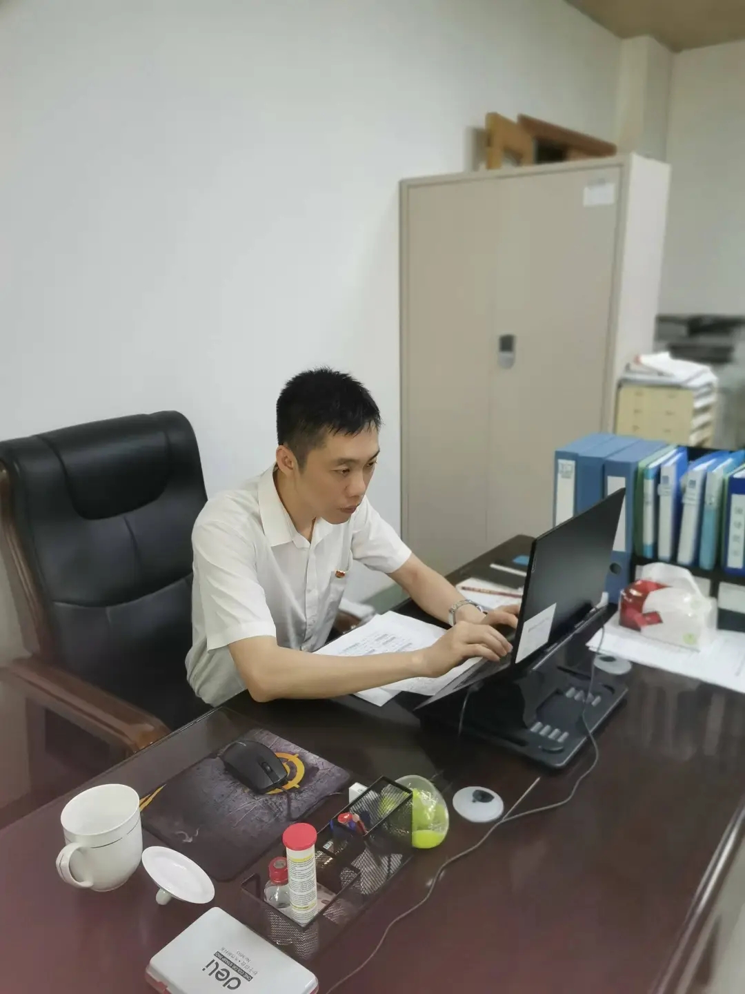 图为周航在办公室撰写工作材料