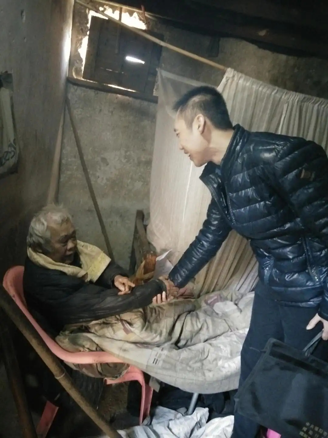 图为周航（右一）入户走访慰问贫困户